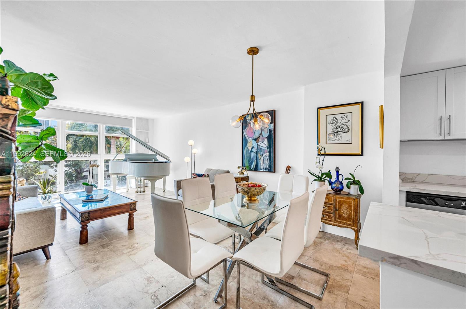 A bright living and dining area features a white grand piano and tile flooring — 1228 West Ave # 209, Miami Beach FL 33139, MIAMI BEACH, FL