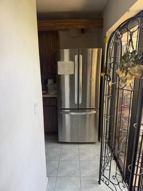 A stainless steel refrigerator stands in a kitchen with tiled floors and wooden cabinets — 319 3rd Way, West Palm Beach FL 33407, WEST PALM BEACH, FL