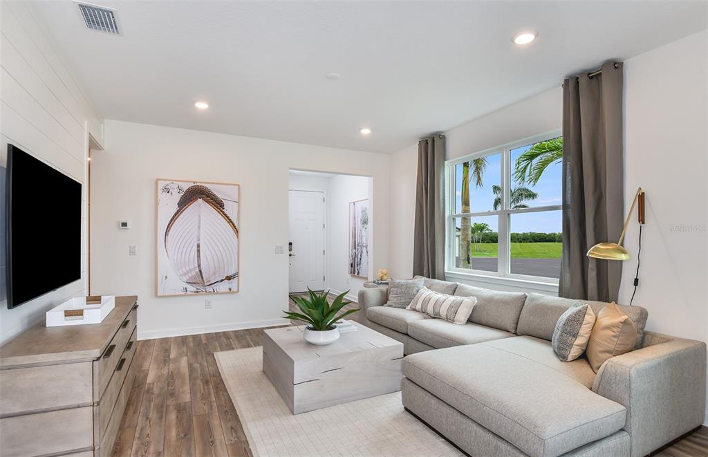 A living room features a sectional sofa, a coffee table, a television, and large windows — 5927 SW 87TH AVENUE, OCALA, FL