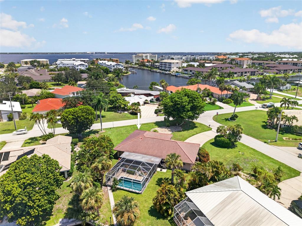 An aerial view shows a house with a tiled roof, pool enclosure, and surrounding landscaping — 401 NORMA COURT, PUNTA GORDA, FL