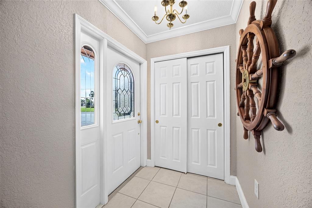 An entryway features a white front door with glass panels, a sliding closet, and tile flooring — 401 NORMA COURT, PUNTA GORDA, FL