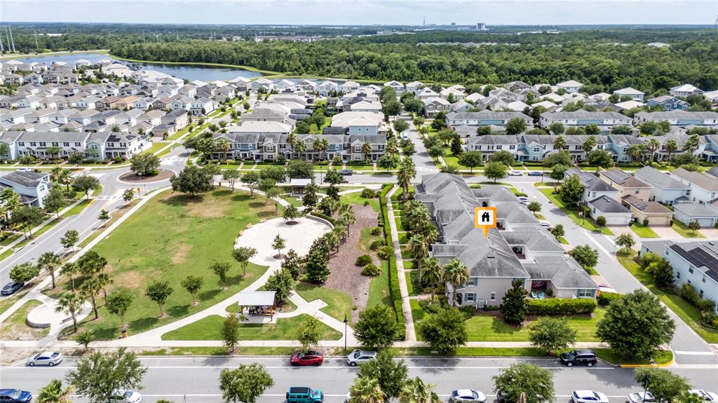 An aerial view shows a residential neighborhood with a park and a multi-unit townhouse building — 11574 COMIC ALLEY, ORLANDO, FL