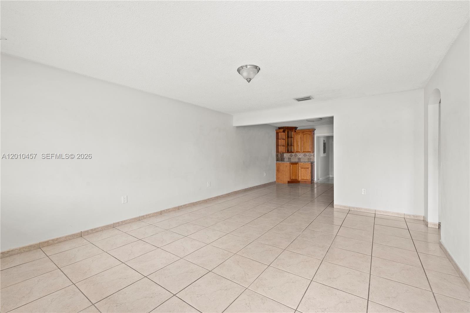 An empty room with white walls, a tiled floor, and a small kitchen area — 1800 SW 97th Ave # A, Miramar FL 33025, MIRAMAR, FL
