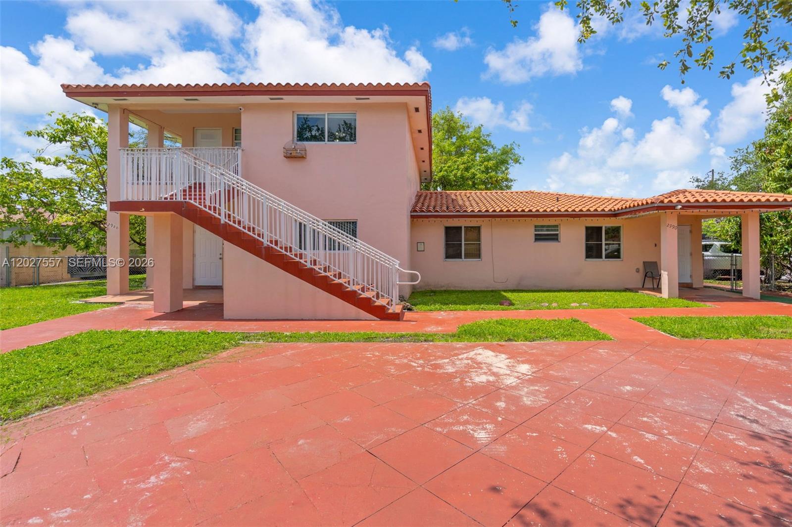 A two-story peach-colored house features an exterior staircase and a red tiled roof — 2986 NW 26th St, Miami FL 33142, MIAMI, FL