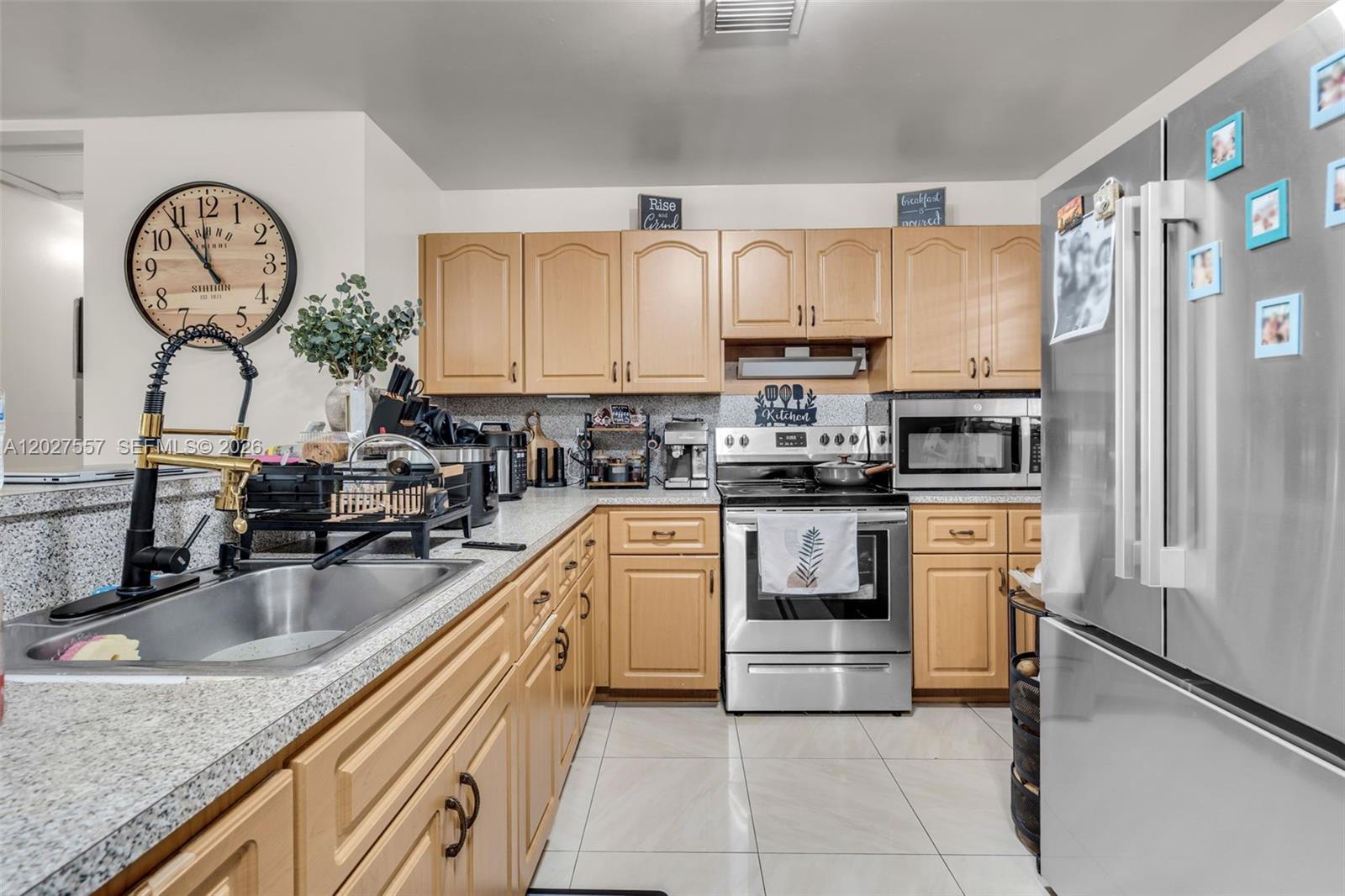 A kitchen features light wood cabinets, stainless steel appliances, and a granite countertop — 2986 NW 26th St, Miami FL 33142, MIAMI, FL