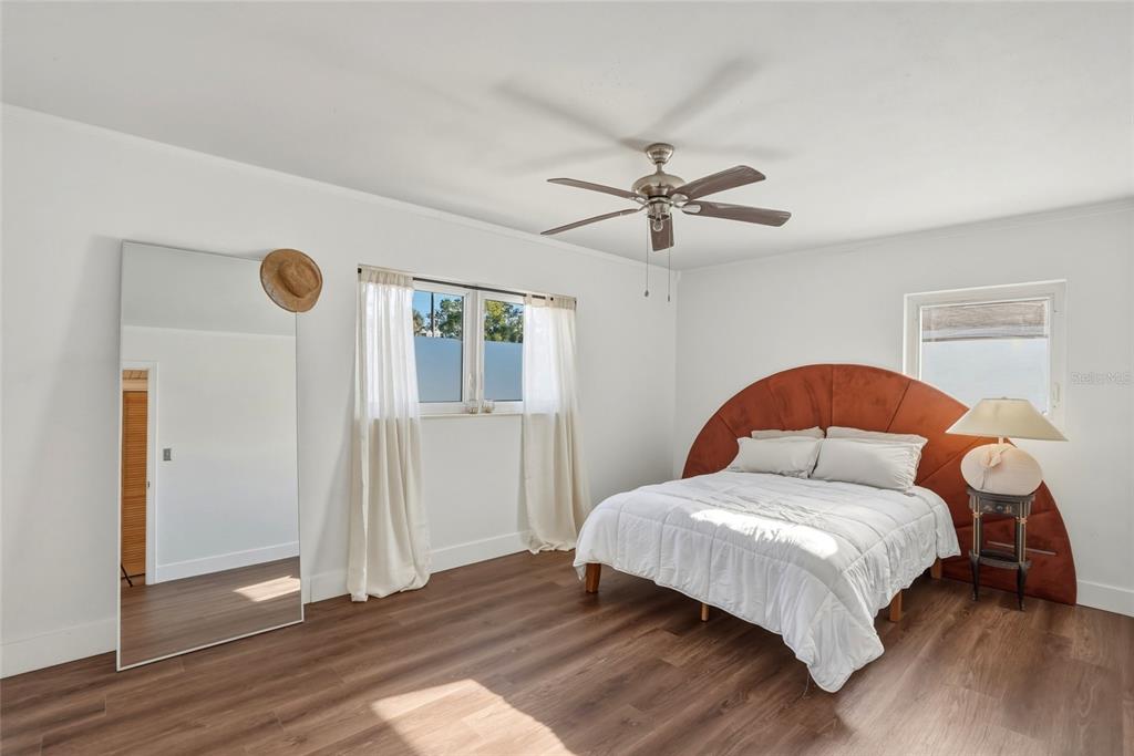 A bedroom features a large arched headboard, a floor mirror, and a ceiling fan — 220 45TH AVENUE S, ST PETERSBURG, FL