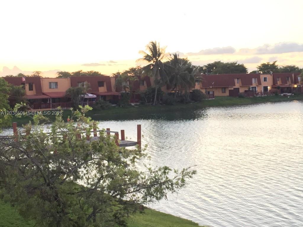 A wooden dock extends into a lake in front of a row of townhouses — 315 NW 109th Ave # 207, Miami FL 33172, MIAMI, FL