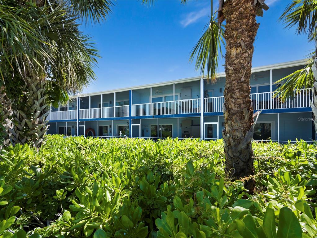 A bright open-concept living and dining area features light wood-look tile flooring and white cabinetry — 2850 GULF OF MEXICO DRIVE UNIT 5, LONGBOAT KEY, FL