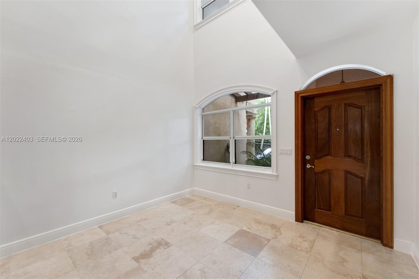 An entryway with high ceilings, tile flooring, a wooden door, and an arched window — 3060 Lime Ct # 3060, Miami FL 33133, MIAMI, FL