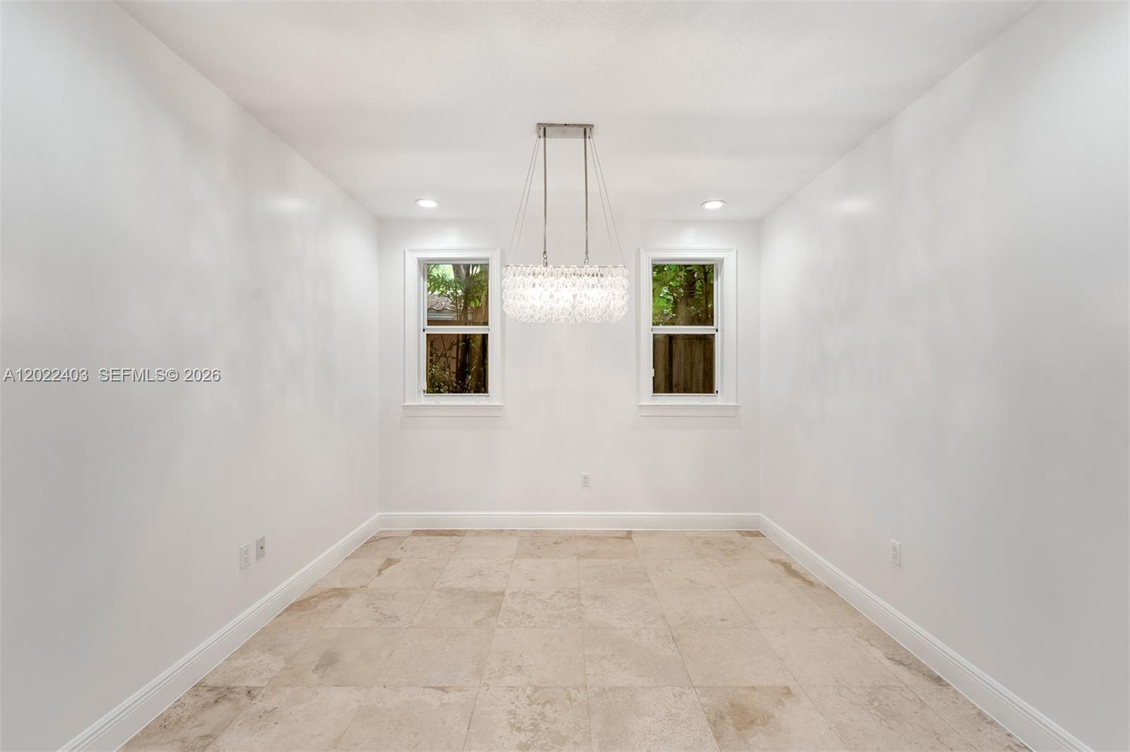 A dining room features white walls, tile flooring, two windows, and a modern crystal chandelier — 3060 Lime Ct # 3060, Miami FL 33133, MIAMI, FL