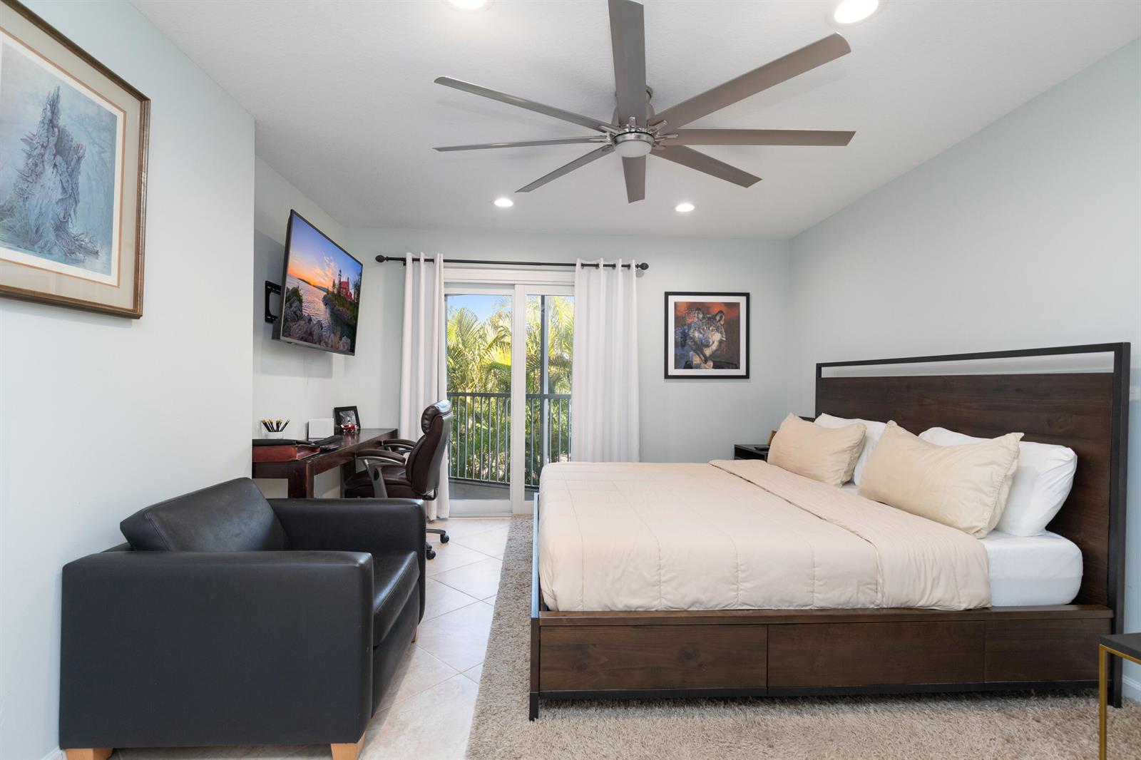 A bedroom features a platform bed, a desk, a leather armchair, and a sliding glass door — 961 S Ocean Drive # 302, Deerfield Beach FL 33441, DEERFIELD BEACH, FL