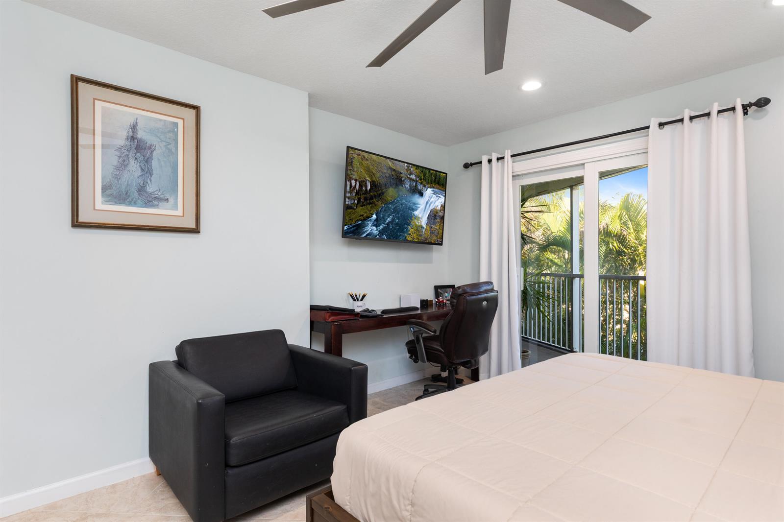 A bedroom features a bed, a black armchair, a desk with a chair, and a balcony — 961 S Ocean Drive # 302, Deerfield Beach FL 33441, DEERFIELD BEACH, FL