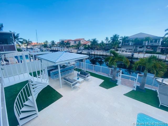 An outdoor patio features a spiral staircase, a covered bar area, and a canal view — 203 Atlantic Blvd # 203, Key Largo FL 33037, KEY LARGO, FL