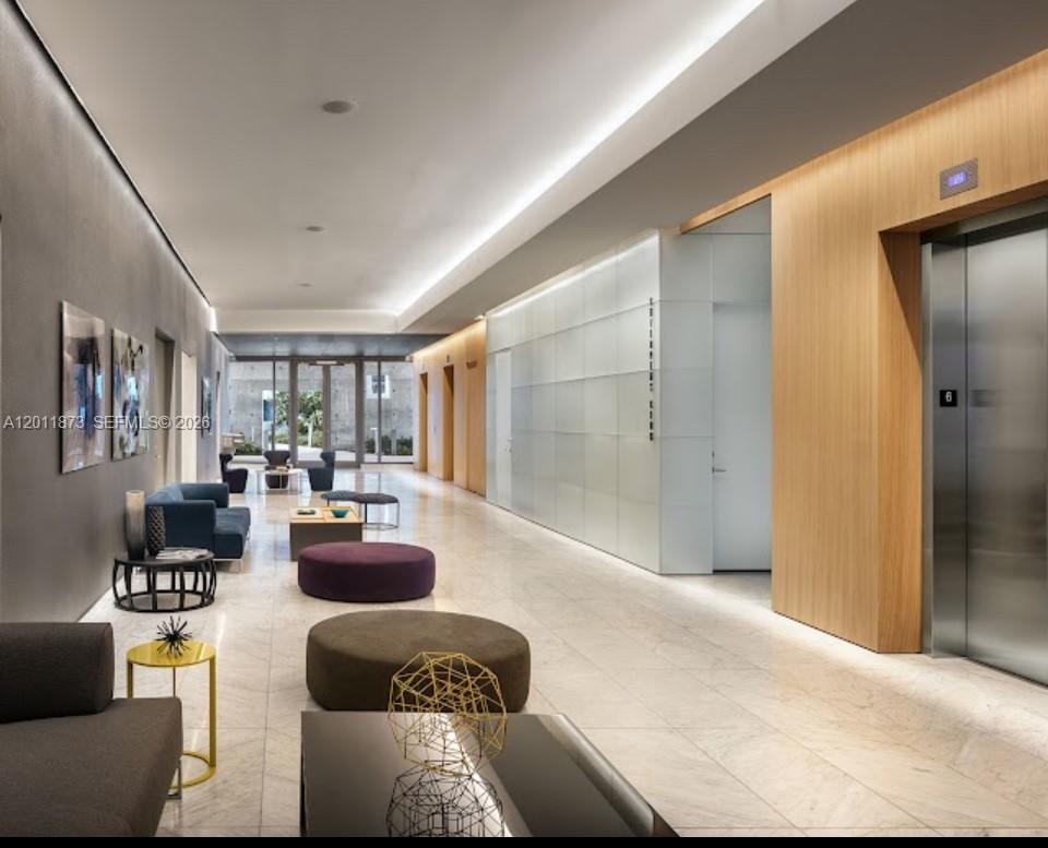 A modern office lobby features a marble floor, elevator bank, and contemporary lounge seating area — 88 SW 7 # 2112, Miami FL 33130, MIAMI, FL