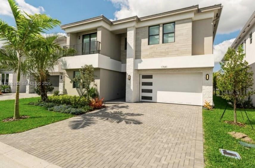 A two-story modern house features a paved driveway, a two-car garage, and a balcony — 17041 Teton River Rd, Boca Raton FL 33496, BOCA RATON, FL