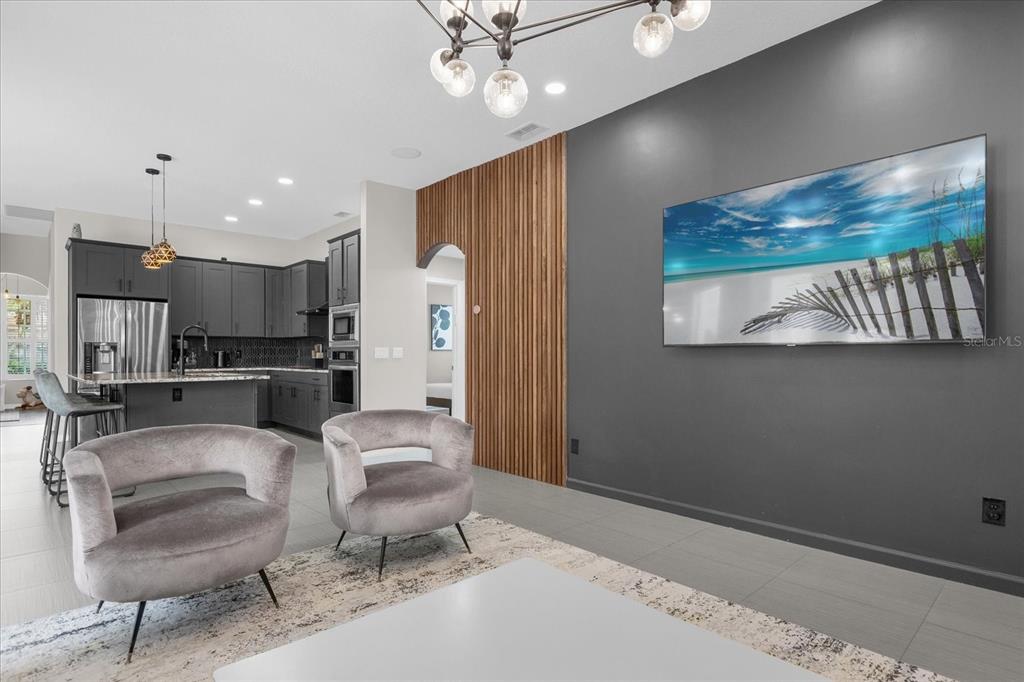 A modern living room features gray walls, a wood slat accent wall, and two armchairs — 10175 COVE LAKE DRIVE, ORLANDO, FL