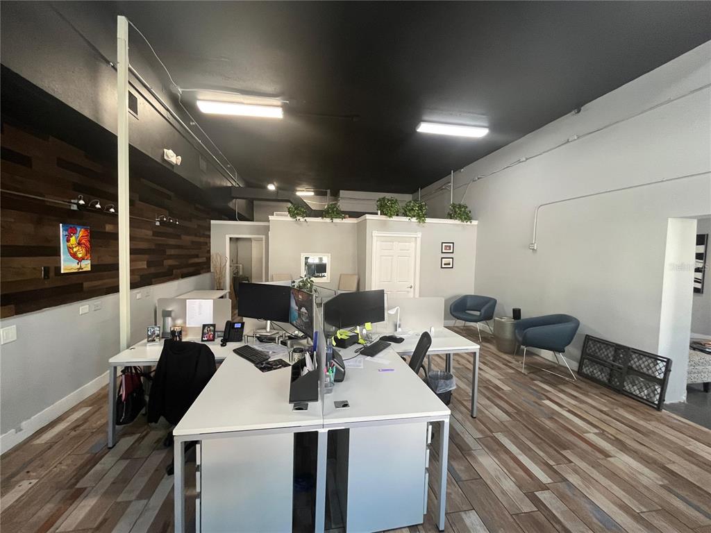 An office space features white desks, a wood-paneled accent wall, and a black ceiling — 1501 E 9TH AVENUE UNIT A, TAMPA, FL