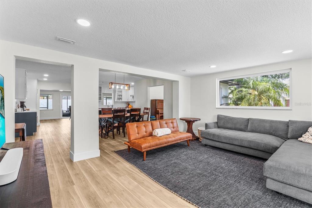 A living room with a gray sectional, leather sofa, and an open view to the dining area — 628 ONTARIO AVENUE, TAMPA, FL