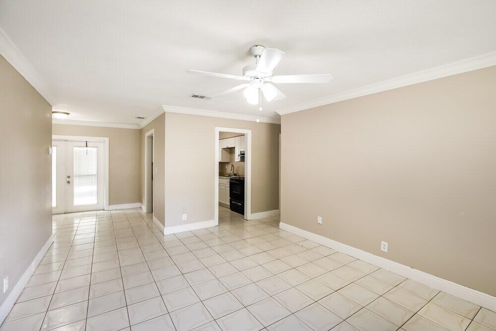 A room with beige walls, white crown molding, and light-colored tile flooring — LAUDERHILL, FL