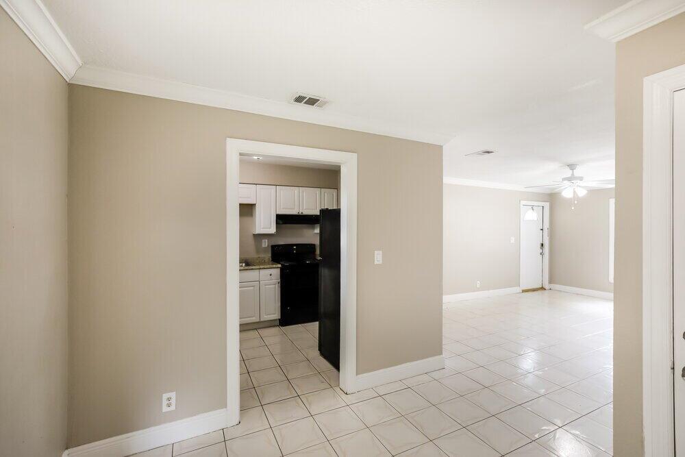 A view from a tiled room looking into a kitchen and an adjacent living area — LAUDERHILL, FL
