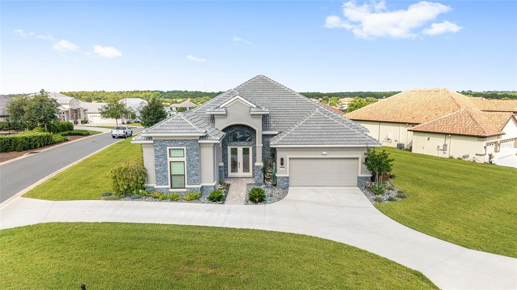 A single-story house with a gray tile roof, stone facade, and a two-car garage — 1500 W ALTON BAY PLACE, HERNANDO, FL
