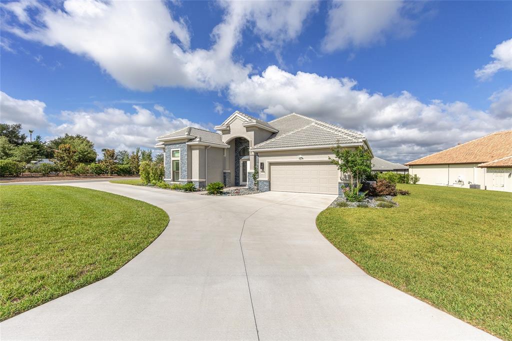 A single-story house with a beige stucco exterior, a tile roof, and a concrete driveway — 1500 W ALTON BAY PLACE, HERNANDO, FL