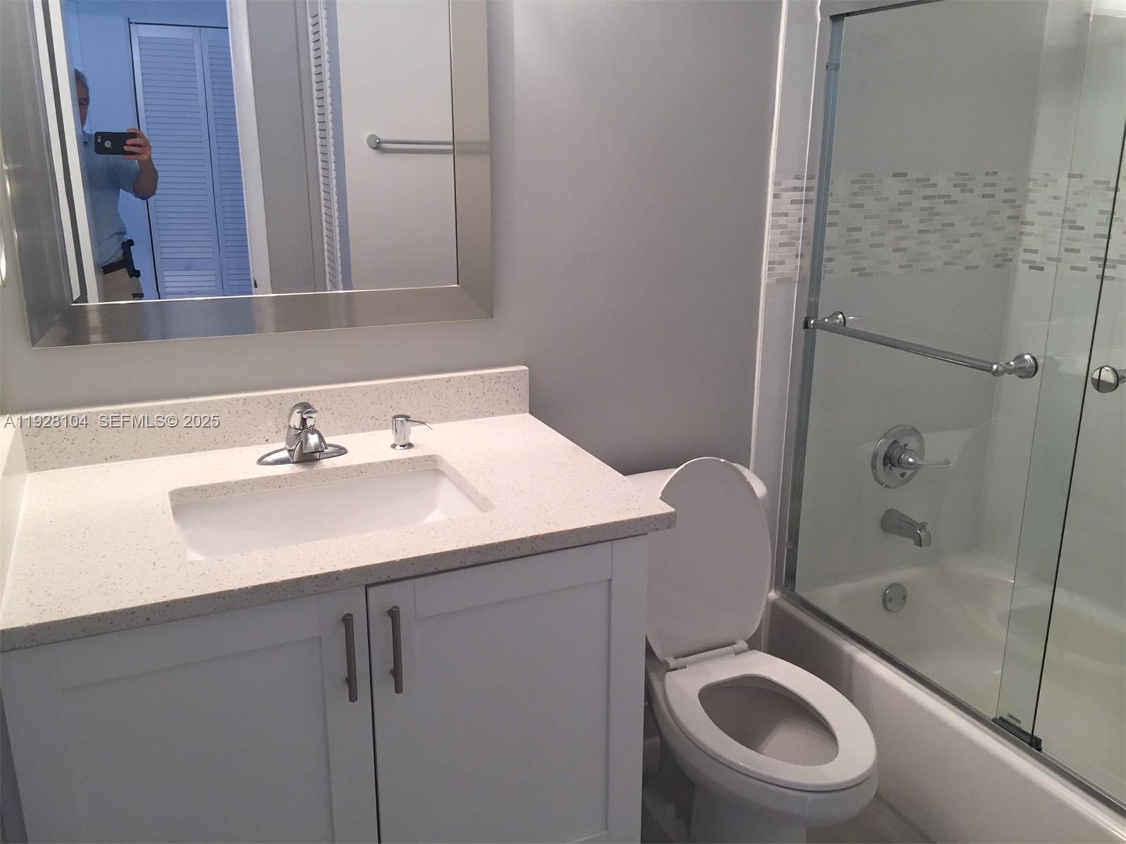 A bathroom features a white vanity with a stone countertop, a toilet, and a shower-tub — 10740 N Kendall Dr # 24, Miami FL 33176, MIAMI, FL