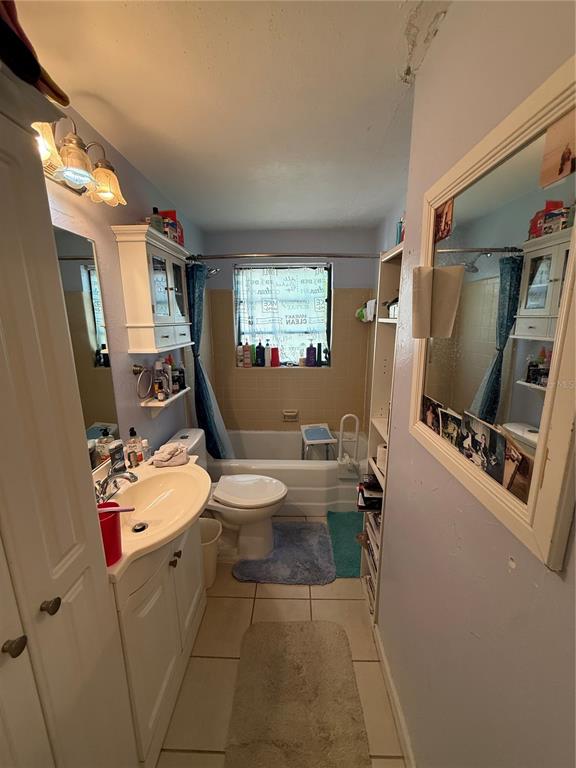 A bathroom features a vanity, a toilet, a bathtub with a shower, and a large mirror — 202 FAIRMONT DRIVE, SANFORD, FL