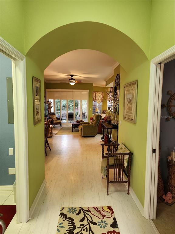 An arched entryway leads into a living room with light wood flooring and green walls — 400 RAVINIA CIRCLE UNIT 400, VENICE, FL