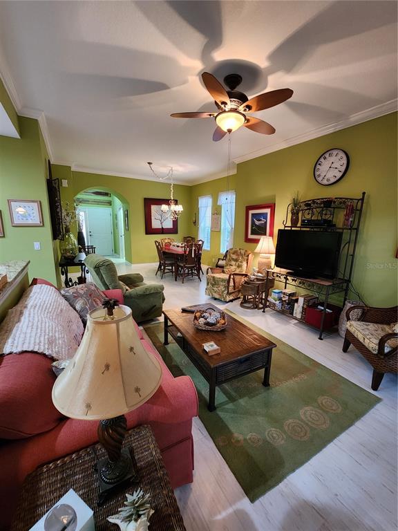 A living room with lime green walls, a ceiling fan, and a red sofa — 400 RAVINIA CIRCLE UNIT 400, VENICE, FL