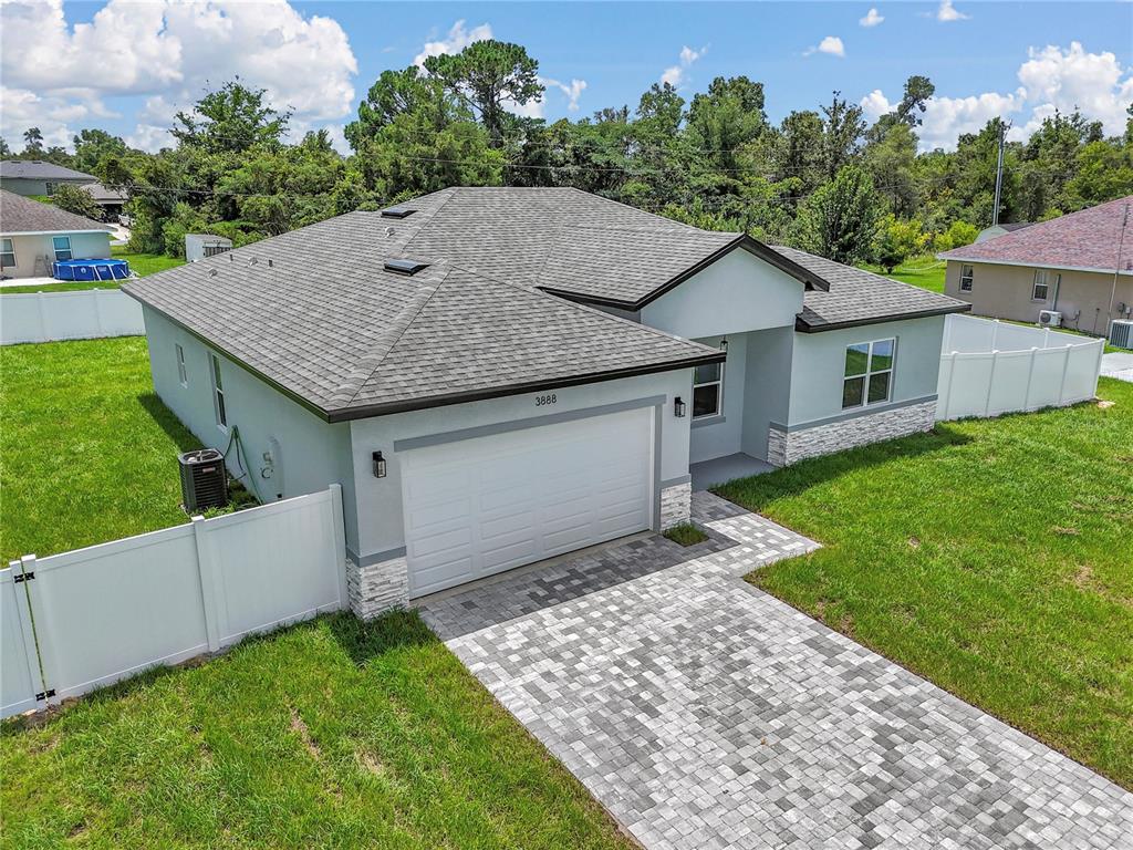 An aerial view of a single-story house with a gray roof and paver driveway — 3888 SW 157TH PLACE ROAD, OCALA, FL