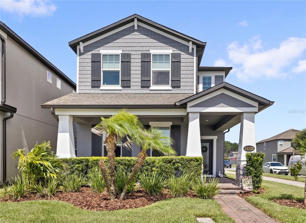 A two-story house with gray siding, a front porch, and a landscaped front yard — 13155 SPRING GROVE WAY, WINTER GARDEN, FL