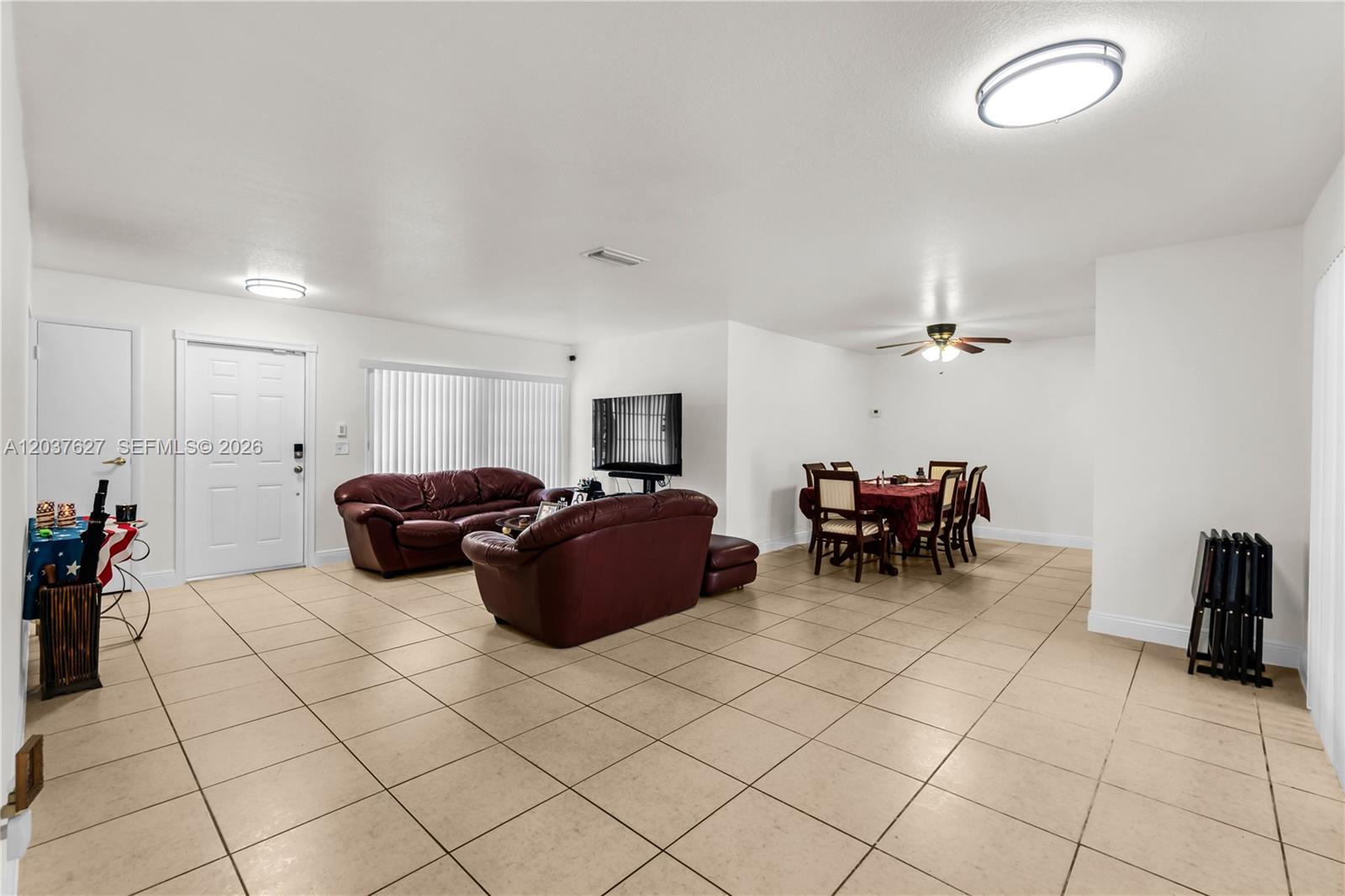 An open-concept living and dining area features white walls and light-colored floor tiles — 2751 NW 107th Ter, Sunrise FL 33322, SUNRISE, FL