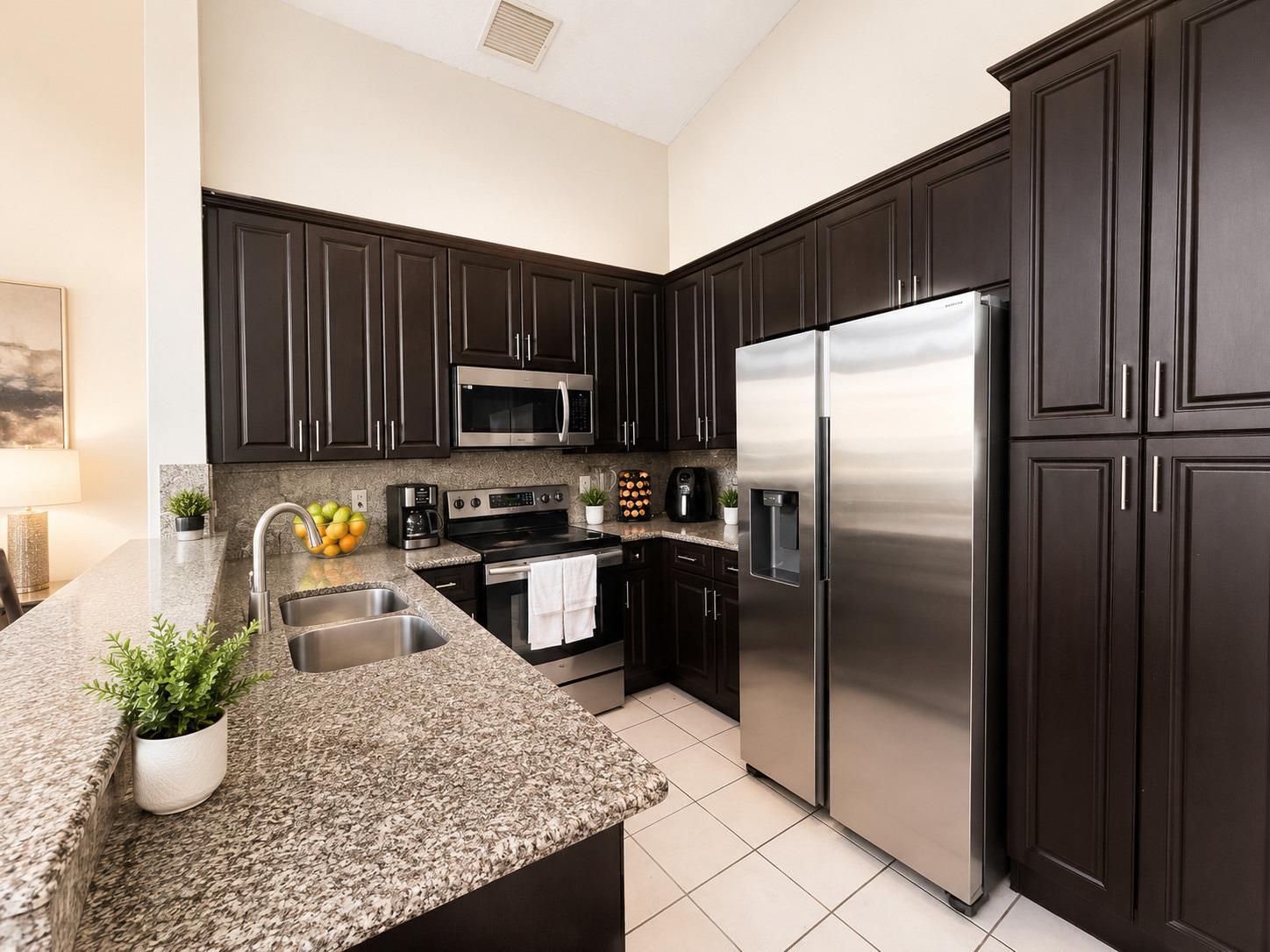 A kitchen features dark wood cabinets, granite countertops, stainless steel appliances, and tile flooring — 3071 Dogwood Lane, Margate FL 33063, MARGATE, FL