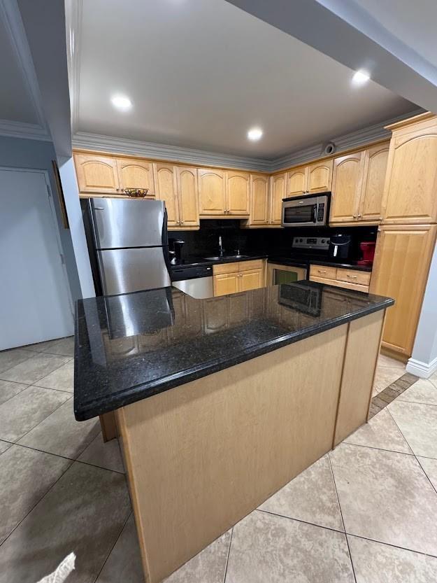 A kitchen features light wood cabinets, black granite countertops, stainless steel appliances, and tile flooring — 700 SE 2nd Avenue # 409, Deerfield Beach FL 33441, DEERFIELD BEACH, FL