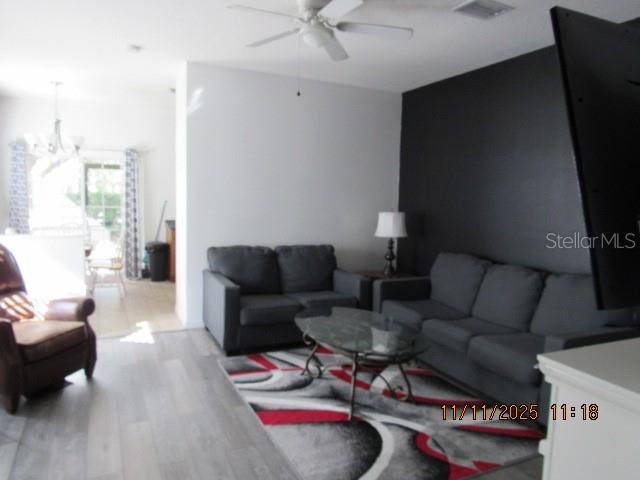 A living room features gray sofas, a patterned area rug, and a dark accent wall — 1944 GREENWOOD VALLEY DRIVE, PLANT CITY, FL