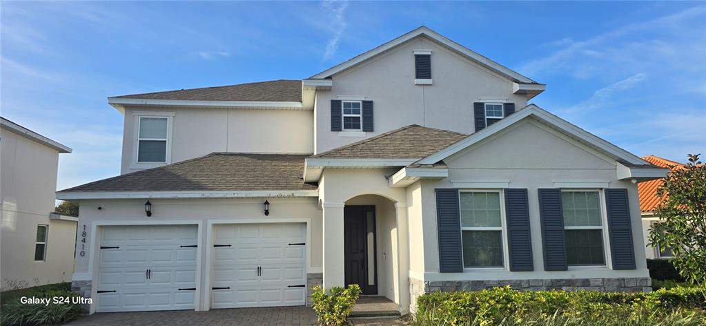A two-story suburban house with a two-car garage, stucco exterior, and dark shutters — 18410 BLUE HERON CIRCLE, DEER ISLAND, FL