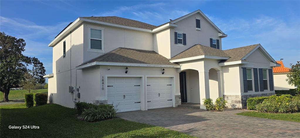 A two-story house with a two-car garage, stucco exterior, and a paved driveway — 18410 BLUE HERON CIRCLE, DEER ISLAND, FL