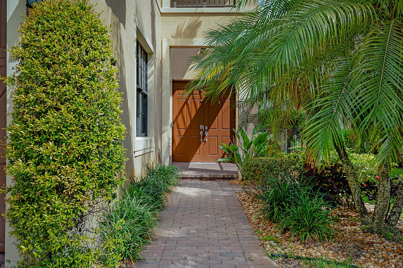 A brick walkway leads to the brown double front doors of a stucco house — 7593 NW 113th Avenue, Parkland FL 33076, PARKLAND, FL