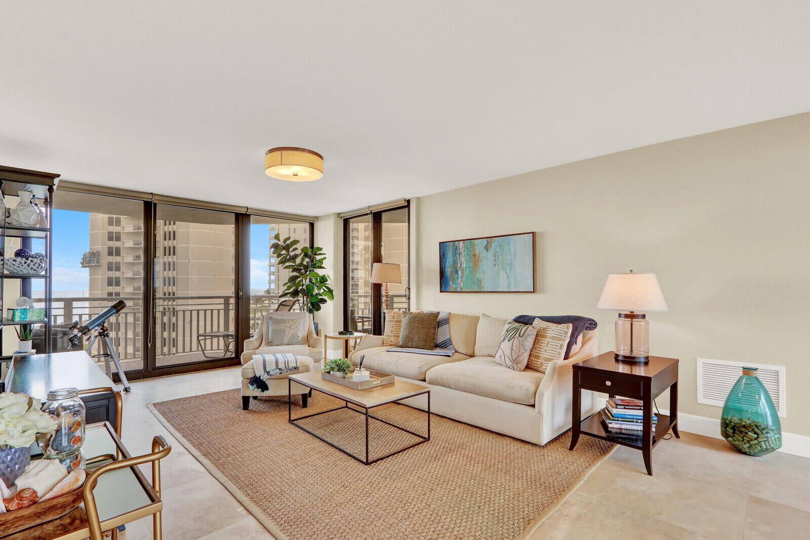 A living room features a beige sofa, a coffee table, and a balcony with city views — 3000 N Ocean Drive # 7h, Singer Island FL 33404, SINGER ISLAND, FL