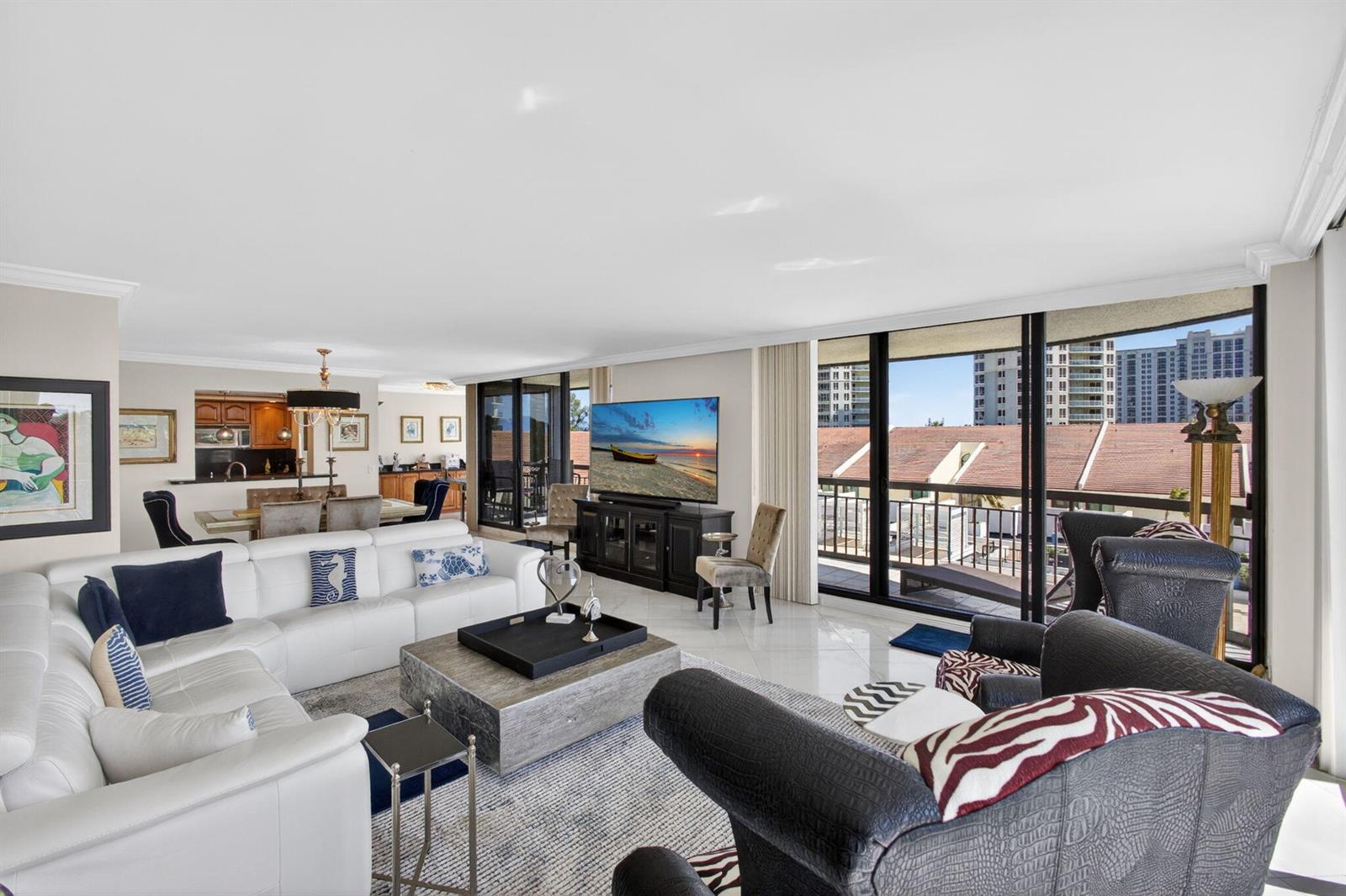 A living room features a white sectional sofa, a coffee table, and large floor-to-ceiling windows — 4100 N Ocean Drive # 304, Riviera Beach FL 33404, RIVIERA BEACH, FL