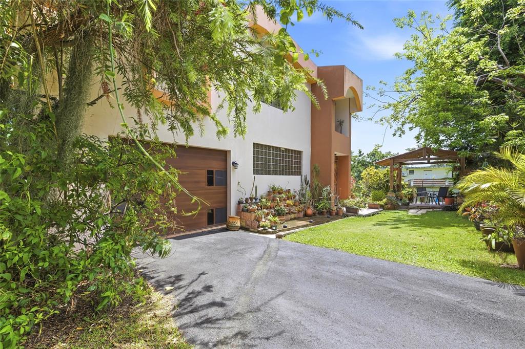 A two-story house with a garage, a glass block window, and a backyard wooden gazebo — 10 FORTUNA 27 A, LUQUILLO, PR