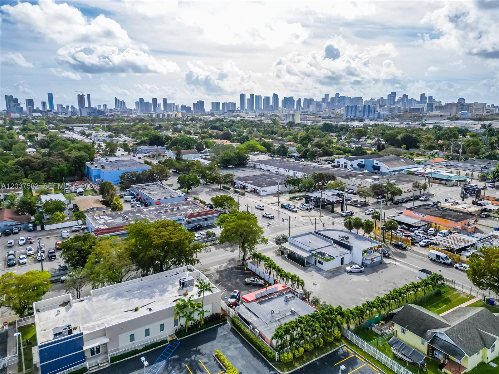 An aerial view shows a commercial area with low-rise buildings and a distant city skyline — 2928 NW 17th Ave, Miami FL 33142, MIAMI, FL