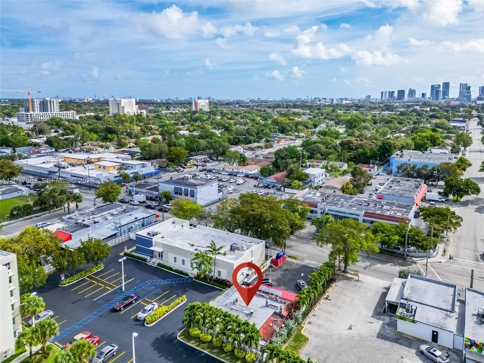 An aerial view shows a commercial building with a parking lot and surrounding urban landscape — 2928 NW 17th Ave, Miami FL 33142, MIAMI, FL