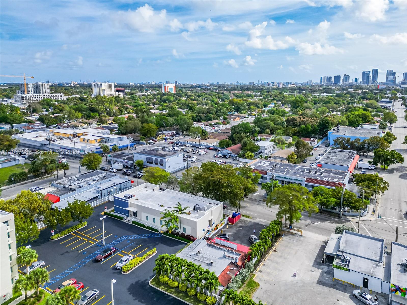 An aerial view shows a commercial building with a parking lot and surrounding urban landscape — 2928 NW 17th Ave, Miami FL 33142, MIAMI, FL