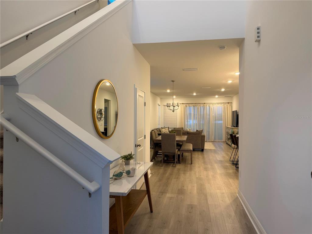 A view from an entryway looking toward a dining area and living room with flooring — 2189 SUNSHINE PEAK DRIVE, MINNEOLA, FL