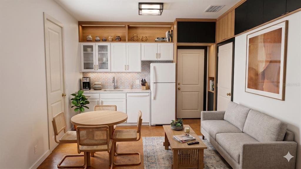 A small kitchen and living area with white cabinets, a round table, and a sofa — 477 SAYRE ROAD SW, PALM BAY, FL