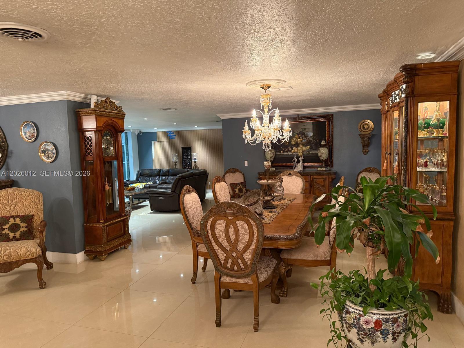 A dining room features a wooden table, ornate chairs, a crystal chandelier, and a grandfather clock — 5540 SW 63rd Ct # 0, Miami FL 33155, MIAMI, FL