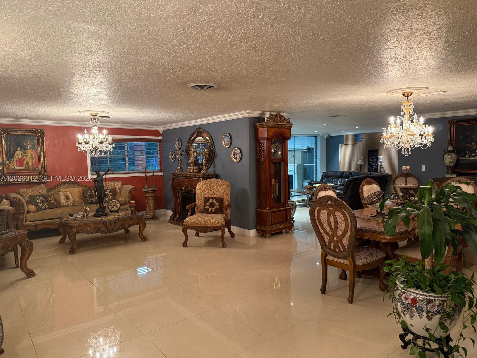 A spacious living and dining area features tile floors, ornate furniture, and two crystal chandeliers — 5540 SW 63rd Ct # 0, Miami FL 33155, MIAMI, FL