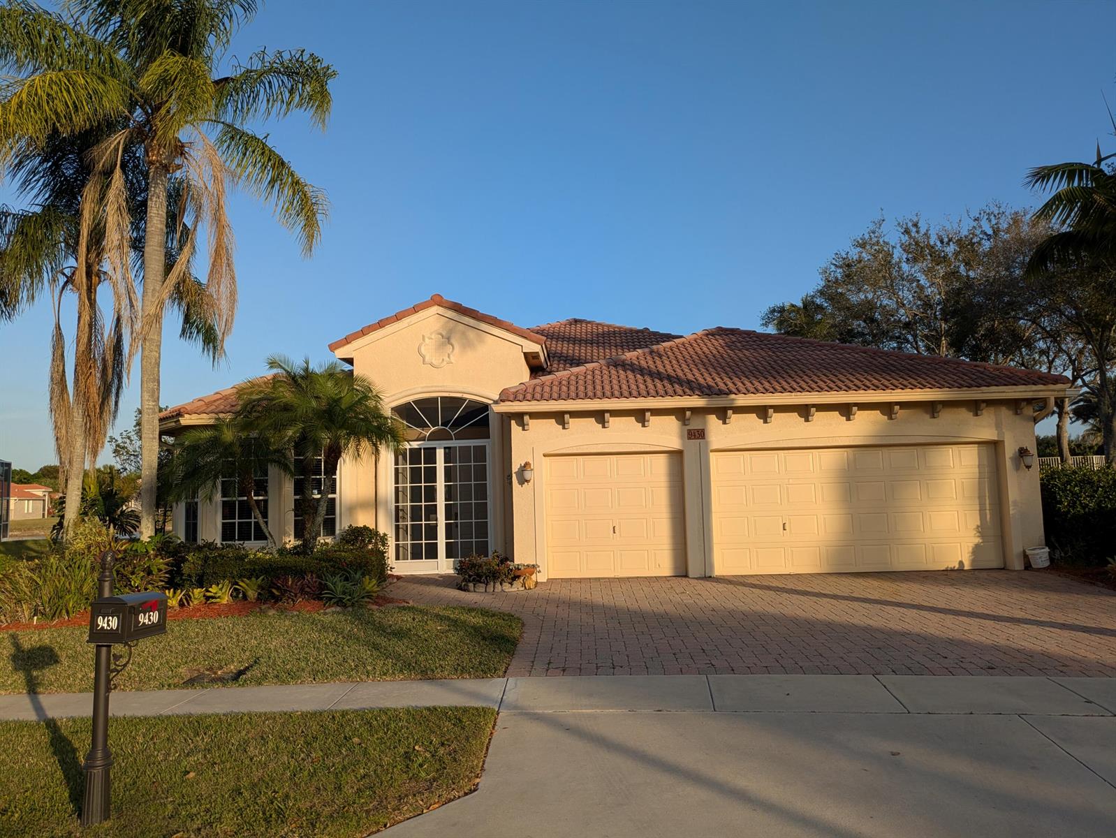 A single-story stucco house with a tile roof, two-car garage, and a paved driveway — 9430 Lantern Bay Circle, West Palm Beach FL 33411, WEST PALM BEACH, FL